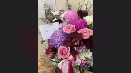 A bouquet of flowers and a handwritten card prepared for a community visit